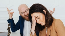 A man angrily shouting at a distressed colleague, symbolizing emotional mismanagement and the need for AI-supported anger management training.