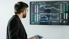 Professional analysing digital charts on a screen, symbolising AI-powered analytics, data-driven insights and advanced strategies in digital marketing.