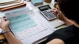 Professional accountant reviewing financial documents and using a calculator — learn how to balance a balance sheet in this CPD course.