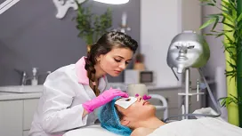 A beauty therapist applying a facial treatment to a client in a modern salon, representing Level 3 beauty therapy and salon management training.