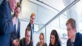 Business professionals gathered around a table discussing plans, representing core skills in organisation, communication and business administration