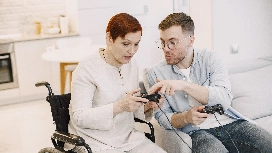 Caregiver communicating with an older adult during a shared activity, demonstrating effective caregiving communication skills