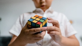 Person solving a puzzle cube, demonstrating creative thinking for problem solving and analytical skills