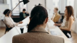 Leader facing a team during a tense meeting, symbolizing communication, decision-making and leadership skills essential in crisis management courses.