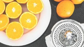 Fresh oranges and a juicer on a kitchen counter, symbolizing natural detoxification, digestive health and nutrient-rich foods explored in nutrition courses.