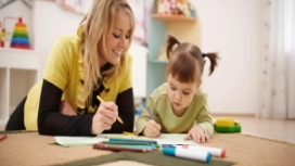 Adult supporting a child during learning activity, illustrating emotional intelligence, empathy and communication skills