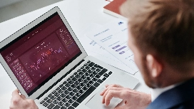 Professional analysing Excel dashboard reports on a laptop, demonstrating data visualisation and reporting skills