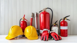 Firefighter in full protective gear spraying water on flames – learn fire safety and prevention with OHSC.