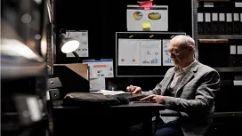 Professional working with financial documents and charts in an office setting, representing advanced forensic accounting training.