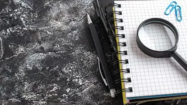 Magnifying glass on a notebook symbolising investigation and analysis – explore forensic accounting with a Level 4 diploma