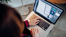 Freelancer working on a laptop creating digital content and managing online projects from a remote workspace