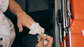 Healthcare worker putting on protective gloves during workplace safety and emergency response procedures training