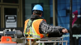 Facilities worker in hard hat and safety vest carrying out site maintenance – Health & Safety in Facilities short course