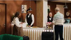 Hotel reception staff assisting guests during check-in, showcasing customer service and front-desk skills taught in hotel management courses.