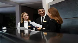 Hotel reception staff reviewing documents together, demonstrating advanced hospitality operations, teamwork, and leadership skills taught in hotel management courses.