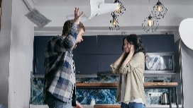 A man and woman in a heated argument with papers flying, symbolizing unmanaged disputes and the need for effective conflict resolution skills at work.