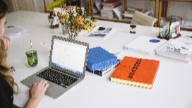 Professional working on a laptop with files and documents, symbolizing digital HR processes and AI-enhanced tools used in modern human resource management.