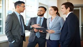 Group of professionals engaged in a discussion in an office setting, symbolizing interpersonal communication and collaboration enhanced by AI tools.