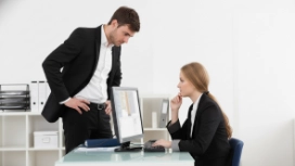 Business managers discussing decisions at a computer, illustrating leadership, coaching and workplace decision-making skills