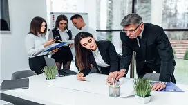 Team of professionals reviewing documents and collaborating in an office setting, representing foundational skills in the Leadership and Management Level 1 Award.