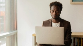 IT student studying on a laptop in a modern workspace, representing learning through an online information technology program Level 4.