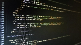 Web design student reviewing HTML and CSS code on screen, representing skills taught in an online web design course Level 4.