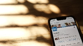 Professional updating a LinkedIn profile and CV online, focusing on CV enhancement and career networking opportunities