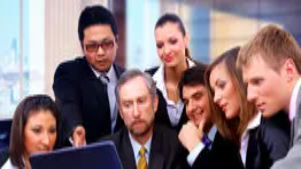 Group of business professionals reviewing information on a laptop, representing leadership, planning, and decision-making in management Level 3 training.