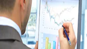 A professional reviews charts and graphs on a tablet, analyzing marketing data and trends to support strategic decision-making and customer-focused marketing.