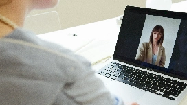 Professional attending a virtual meeting on a laptop, demonstrating online communication and collaboration skills