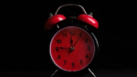 Red alarm clock illustrating the Pomodoro method timer for effective time management, focus and productivity