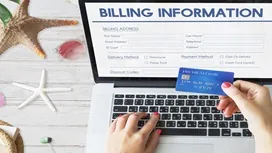 Hands entering billing details on a laptop with a credit card, representing online accounting and QuickBooks financial management training.
