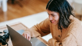 Woman working on laptop from home, exploring remote public relations skills with OHSC Remote PR free course