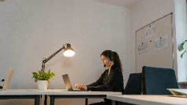 Remote office administrator working on a laptop in a modern workspace, representing remote work careers and virtual assistant roles