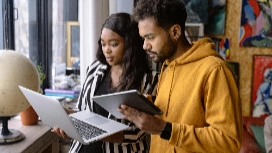 Two professionals reviewing notes on laptop and tablet, illustrating report writing stages – online trainer short course