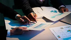 Business professionals reviewing charts and risk reports at a desk, illustrating core concepts taught in introductory risk management courses.