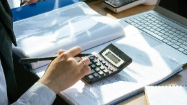 Accountant using calculator and reviewing financial files – explore the role of an accountant short course online with OHSC
