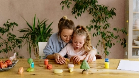 Adult guiding two children in creative play at home, highlighting safe support – study safeguarding children short course