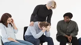 Support group comforting a distressed person, illustrating awareness of physical discomfort and emotional strain linked to recognising strep throat symptoms.