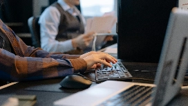 Person practising on a keyboard to enhance speed and accuracy, learning how to improve typing skills and regular typing speed techniques