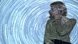 Person illuminated by swirling digital light patterns, representing the creative image-generation and diffusion processes used in Stable Diffusion AI.