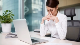 Professional managing workplace stress at a desk, illustrating stress management, mindfulness and emotional wellbeing skills