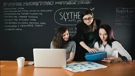 Group of students collaborating with a laptop and notes in a classroom, symbolizing supervised learning techniques and collaborative model training concepts.