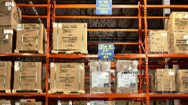 Warehouse shelves packed with cartons and stock labels – study supply chain management (SCM) short course online at OHSC.