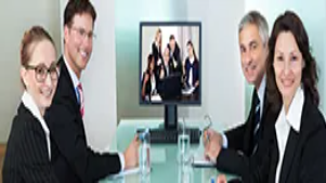 A group of professional trainers in a meeting with a training session displayed on a screen, representing advanced Level 7 trainer development skills.