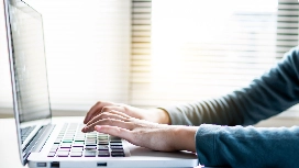 Professional typing on a laptop for data entry work, demonstrating fast typing skills and workplace productivity
