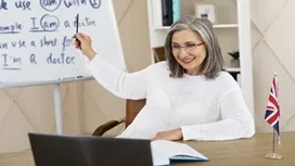 Teacher giving an online lesson with British flag and grammar board, symbolising learning and understanding UK VAT concepts
