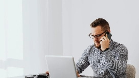 Virtual assistant managing client communication and tasks remotely through laptop and phone during a work session