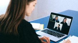 Professional attending a virtual interview on laptop, demonstrating preparation of the interview and online communication skills