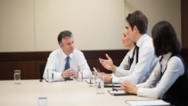 Professionals discussing workplace matters, illustrating negotiation skills, communication and successful business collaboration